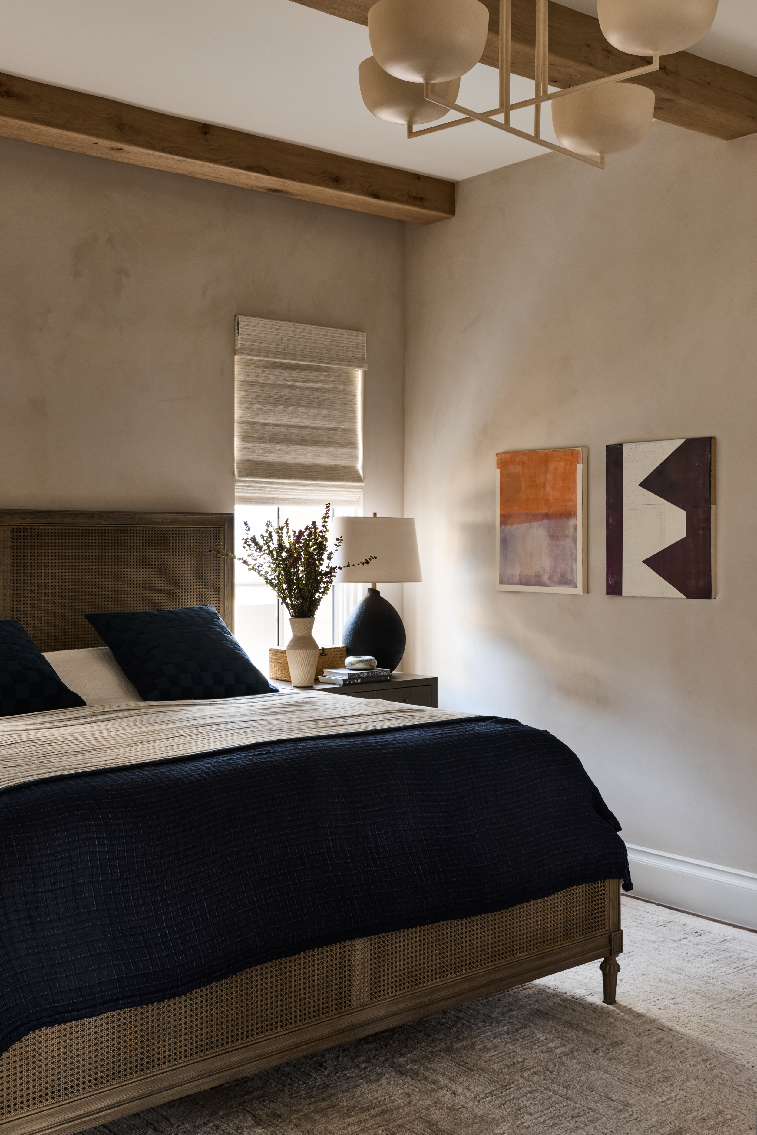 Bedroom with plaster walls, oak beams, and woven cane bed