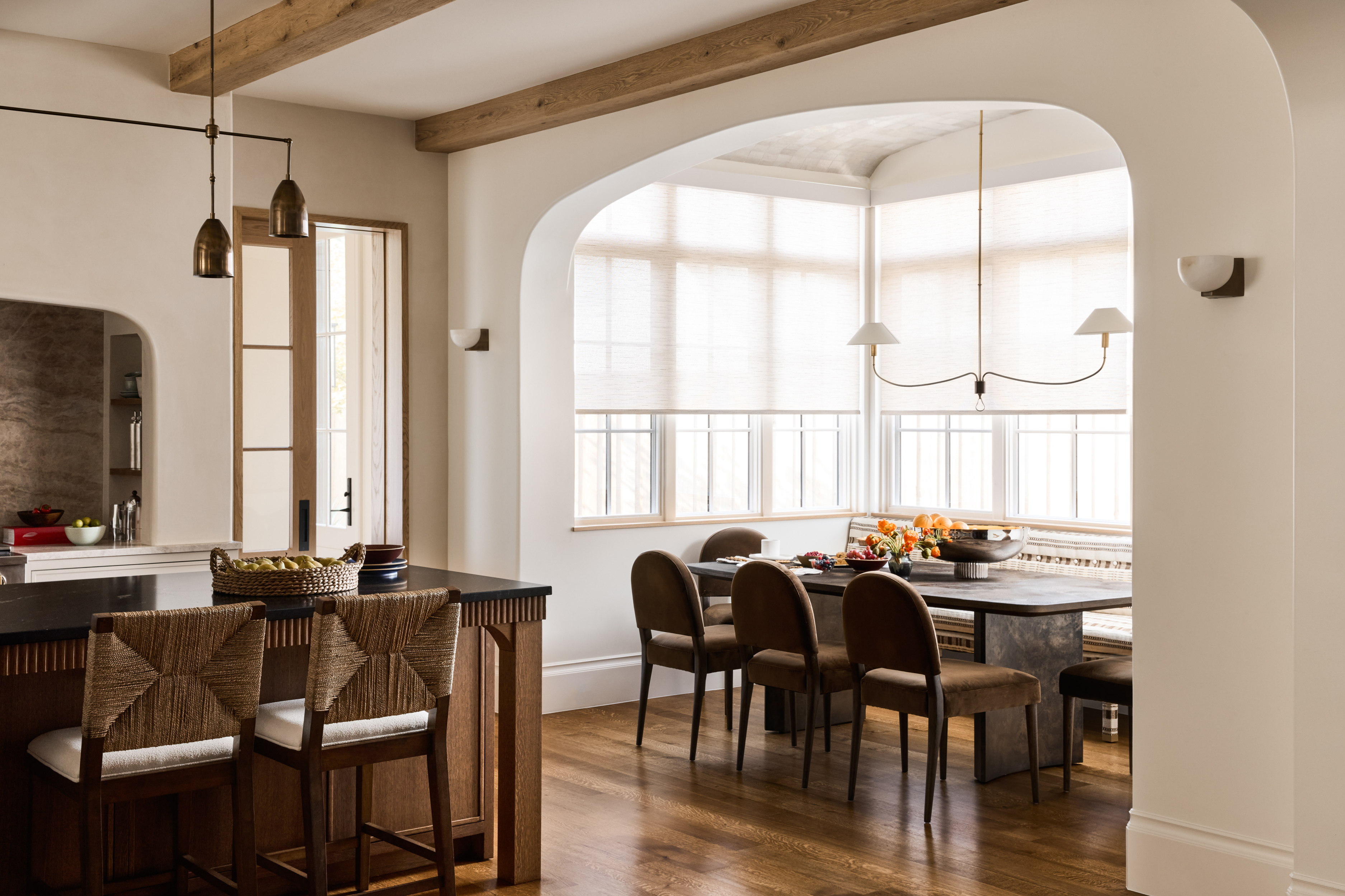 Breakfast room with curved opening and sculptural brass pendant